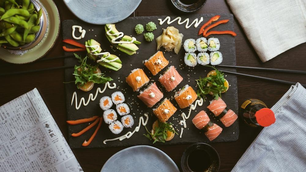 A beautifully arranged platter of sushi with various types of fish and garnishes.