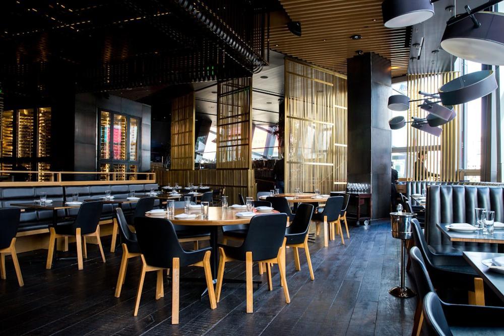 A cozy fall-themed restaurant setting in NYC with autumn decor and ambient lighting.